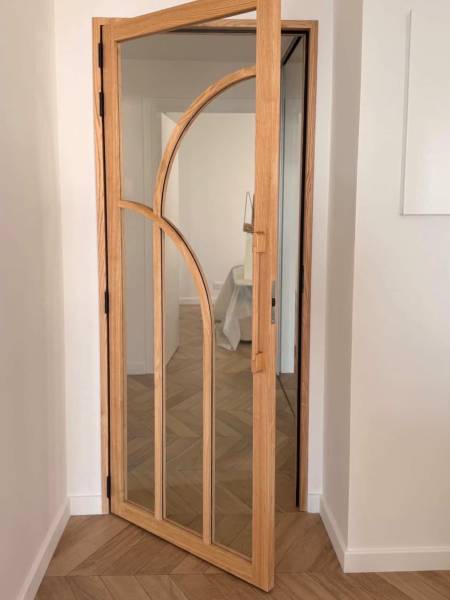 Porte verrière battante en châtaignier massif avec poignées sur mesure uniques, conçue artisanalement en Provence-Alpes-Côte-d’Azur