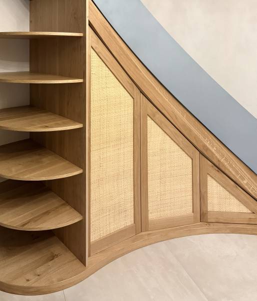 Agencement sous escalier en bois sur mesure réalisé par un artisan menuisier à Neuchâtel – entreprise de menuiserie bois Le Maillet Bleu